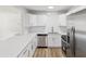 Modern kitchen with stainless steel appliances, white cabinets, and quartz countertops at 1843 Berg Rd, Holiday, FL 34690