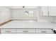 Modern kitchen showcasing an island with white cabinets, light countertops and stylish hardware at 1843 Berg Rd, Holiday, FL 34690