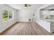 Bright living room featuring natural light, modern ceiling fan, and newly installed wood-look floors at 1843 Berg Rd, Holiday, FL 34690