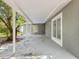 View of covered patio with concrete floor, mature trees, and view of main house with door at 1843 Berg Rd, Holiday, FL 34690