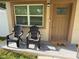 Inviting front porch features two chairs, a neutral color scheme, and a 'hello' door mat at 1913 W Saint Conrad St, Tampa, FL 33607