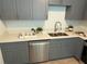 Stylish kitchen featuring gray cabinets, stainless steel appliances, and quartz countertops at 1913 W Saint Conrad St, Tampa, FL 33607