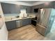 Modern kitchen featuring gray cabinets, stainless steel appliances, and wood-look flooring at 1913 W Saint Conrad St, Tampa, FL 33607