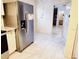 Kitchen featuring tile floors, modern stainless steel refrigerator, and an adjacent room view at 1918 Crown Park Dr, Valrico, FL 33594