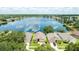 Aerial view showcasing homes near a serene lake with cloud reflections at 2527 Butterfly Landing Dr, Land O Lakes, FL 34638