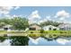 Spacious backyard with lake views reflecting blue skies and fluffy clouds at 2527 Butterfly Landing Dr, Land O Lakes, FL 34638