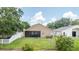 Back exterior view with a screened lanai and a well-maintained lawn at 2527 Butterfly Landing Dr, Land O Lakes, FL 34638