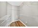 A simple walk-in closet with white racks, wood floors, and white walls at 2527 Butterfly Landing Dr, Land O Lakes, FL 34638