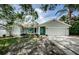Lovely single-story home featuring a blue door, attached garage, and well-maintained landscaping at 2609 Sunnyside Cir, Palm Harbor, FL 34684