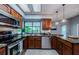 Kitchen featuring stainless appliances, brown cabinets, marble countertops, and natural light at 2609 Sunnyside Cir, Palm Harbor, FL 34684