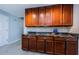 Kitchen featuring brown cabinets, marble countertops, tile backsplash, and tile floor at 2609 Sunnyside Cir, Palm Harbor, FL 34684