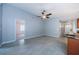 Open-concept living room features gray tile floor, ceiling fan, and neutral walls, with doorways to other rooms at 2609 Sunnyside Cir, Palm Harbor, FL 34684