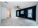 Spacious main bedroom has light carpet, a ceiling fan, and a dark blue accent wall with two windows at 2609 Sunnyside Cir, Palm Harbor, FL 34684