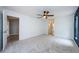 Bright main bedroom features soft carpet, a ceiling fan, and doors leading to other rooms in the home at 2609 Sunnyside Cir, Palm Harbor, FL 34684