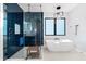 Modern bathroom featuring glass shower, soaking tub, geometric tile, and contemporary lighting fixtures at 2707 Ridgewood Ave, Tampa, FL 33602