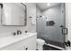 This bathroom features white cabinets and a modern shower with gray tile at 2707 Ridgewood Ave, Tampa, FL 33602