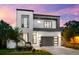 Contemporary two-story home with dark accents, sleek garage door, and a beautifully landscaped front yard at 2707 Ridgewood Ave, Tampa, FL 33602