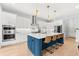 Bright kitchen features white cabinets, quartz countertops, an island with bar stools, and stainless steel appliances at 2707 Ridgewood Ave, Tampa, FL 33602