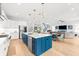 Open-concept kitchen with a navy island, dining area, stainless steel appliances, and a view of the living room at 2707 Ridgewood Ave, Tampa, FL 33602
