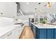 Contemporary kitchen with a blue island, white cabinets, quartz countertops, stainless steel appliances, and pendant lighting at 2707 Ridgewood Ave, Tampa, FL 33602