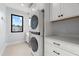 This well-lit laundry room has tile floors, bright white cabinets and stacked washer and dryer at 2707 Ridgewood Ave, Tampa, FL 33602