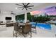 Covered patio with a dining area and comfortable seating overlooking a luxurious pool and backyard at 2707 Ridgewood Ave, Tampa, FL 33602