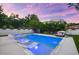 A luxurious pool and spa, surrounded by lush landscaping, create a serene backyard oasis at 2707 Ridgewood Ave, Tampa, FL 33602
