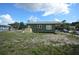 Wide shot of the backyard and side of the house, along with mature landscaping around the property at 3009 N 13Th St, Tampa, FL 33605