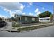 Street corner view of a charming home featuring green exterior, mature trees, and a fire hydrant at 3009 N 13Th St, Tampa, FL 33605