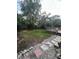 Spacious backyard with wooden deck, stepping stones, landscaping and perimeter fence at 302 W Fern St, Tampa, FL 33604