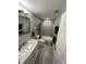 Updated bathroom with a marble vanity, gray tile flooring, and a shower-tub combo featuring decorative accent tiles at 302 W Fern St, Tampa, FL 33604