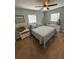 Bedroom with a bed made with blue quilt, a white dresser, side tables, and ceiling fan at 302 W Fern St, Tampa, FL 33604