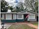 Charming single-story home with a well-maintained front yard, brick walkway and gray and green exterior paint at 302 W Fern St, Tampa, FL 33604
