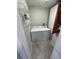 Functional laundry room with washer, dryer, shelving, and tile flooring at 302 W Fern St, Tampa, FL 33604