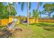 Expansive backyard featuring a yellow house, lush greenery, and tall trees, perfect for outdoor living at 317 Elizabeth Ave, Clearwater, FL 33759