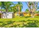 Well maintained backyard features a shed and yellow house with mature palm trees at 317 Elizabeth Ave, Clearwater, FL 33759