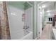 Bright bathroom showcasing a clean, white tiled shower-tub and a view into a neutrally decorated home at 317 Elizabeth Ave, Clearwater, FL 33759