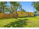 Charming yellow single-story home with a well-manicured lawn and a privacy fence enhancing curb appeal at 317 Elizabeth Ave, Clearwater, FL 33759