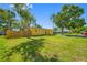 Well-maintained front yard featuring a bright yellow house, lush green lawn, and mature trees under a blue sky at 317 Elizabeth Ave, Clearwater, FL 33759