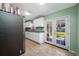 Galley kitchen featuring white cabinets, granite countertops, stainless steel appliances, and French doors to backyard at 317 Elizabeth Ave, Clearwater, FL 33759
