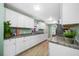 Bright kitchen featuring white cabinets, granite countertops, and stainless steel appliances with natural light at 317 Elizabeth Ave, Clearwater, FL 33759