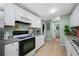 Modern kitchen with white cabinetry, granite countertops, stainless steel appliances, and tile floors at 317 Elizabeth Ave, Clearwater, FL 33759