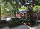 Charming backyard featuring lush landscaping, a red storage shed, and a gazebo with a white picket fence at 4106 N Central Ave, Tampa, FL 33603