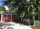 Outdoor shed with a red barn door, gravel path, and a white gazebo in the backyard at 4106 N Central Ave, Tampa, FL 33603
