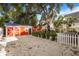 Spacious backyard with a red barn-style shed, rock ground cover, and partial fencing for added charm at 4106 N Central Ave, Tampa, FL 33603