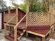 Wooden deck with steps and lattice railing, surrounded by lush greenery, perfect for outdoor entertaining at 4106 N Central Ave, Tampa, FL 33603