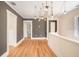 Spacious hallway with wood floors, updated paint scheme and a modern chandelier at 4106 N Central Ave, Tampa, FL 33603