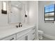 A pristine bathroom features white cabinets, black hardware, and a subway-tiled shower for a fresh and modern feel at 4109 W Inman Ave, Tampa, FL 33609