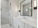 Bathroom featuring dual sinks, a large mirror, and a frameless glass shower at 4109 W Inman Ave, Tampa, FL 33609
