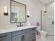 A sleek bathroom features a gray vanity, black hardware, and a modern walk-in shower with white marble surround at 4109 W Inman Ave, Tampa, FL 33609